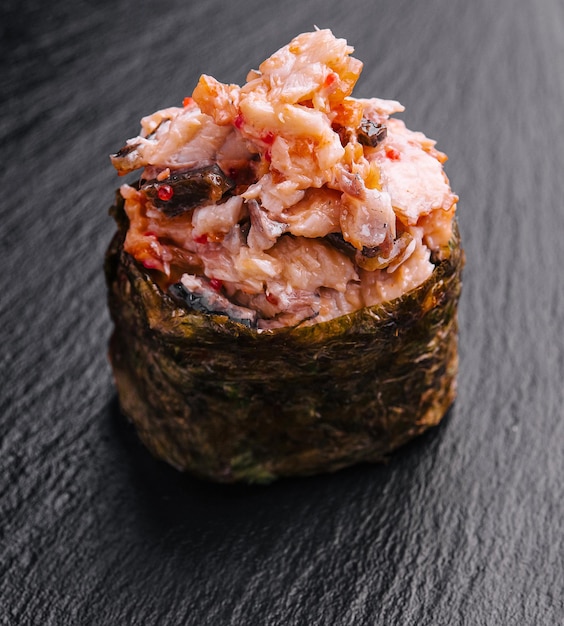 Gunkan sushi with spicy tuna on black desk