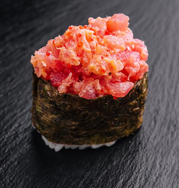 Gunkan sushi with tuna and tobiko on black