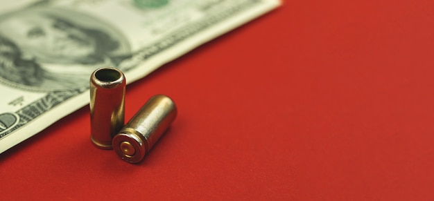 Guns and money, bullet and dollar on red background, criminal and illegal concept, copy space photo