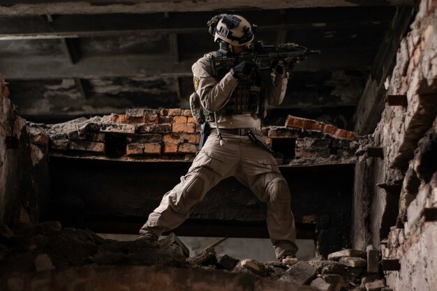 a guy in an american military uniform stands in a dilapidated building on a pile of rooms airsoft