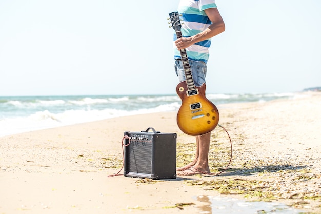 парень на пляже с музыкальными инструментами