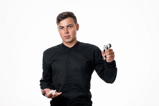 A guy in a black shirt poses with broken cigarettes in one hand and a pack of cigarettes in the other. The concept of giving up cigarettes. Smoking is evil