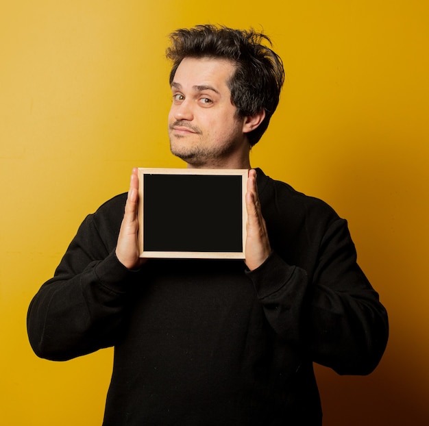 Guy in black shirt with blackboard