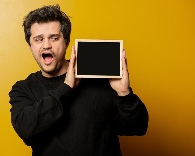 Guy in black shirt with blackboard