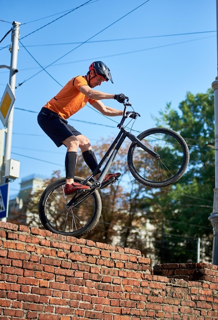 Ragazzo in pantaloncini neri si trova su una ruota della bici sportiva