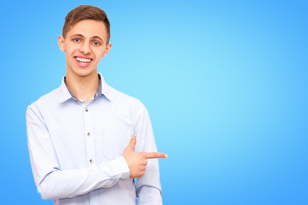 A guy in a blue shirt advertises a product, isolated on a blue background