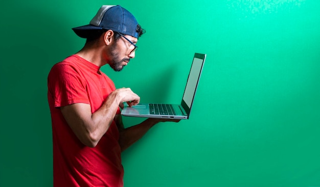 Guy in cap checking his laptop isolated surprised man checking his laptop