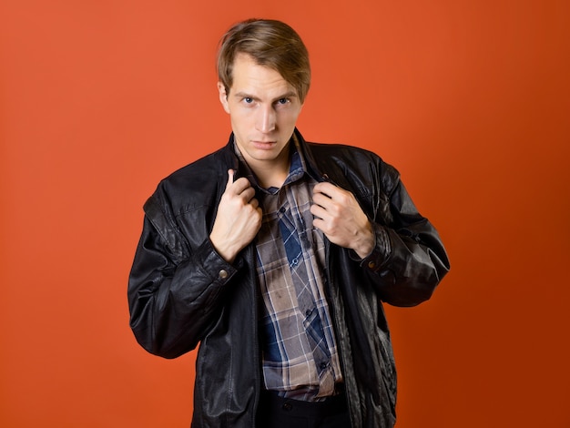 A guy in a casual plaid shirt and a leather jacket studio photo