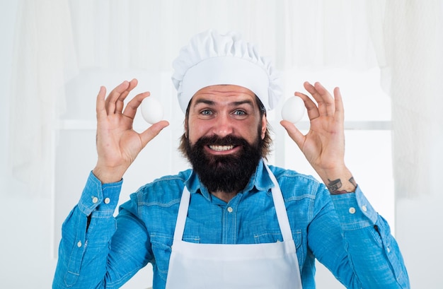 Photo guy chef in hat prepare eggs how to cook eggs