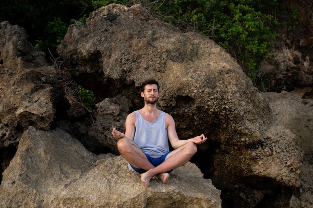 The guy does yoga on the rocks