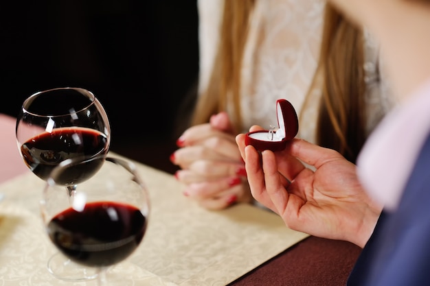 Guy doing his woman a proposal in restaurant