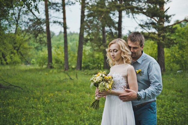 The guy embraces the girl against wood 3261