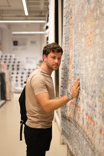 Guy exploring new carpet in decor shop