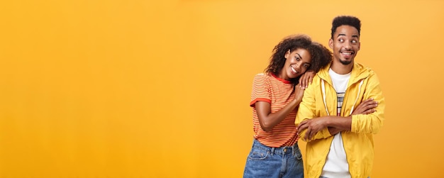 Guy feeling happy girl lean on his shoulder grinning and chuckling from happiness standing pleased