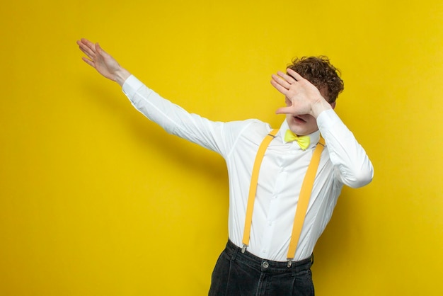 Guy in festive outfit moves his hands to the side student in shirt in bow tie makes dub gesture