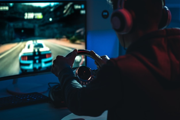 The guy gamer with headphones playing video games in the dark room