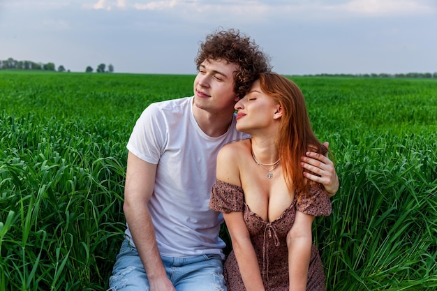 Foto un ragazzo e una ragazza si abbracciano su un campo verde