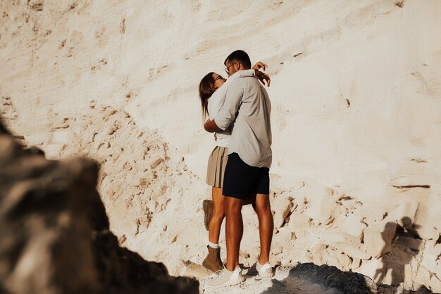 Парень и девушка обнимаются возле белых камней