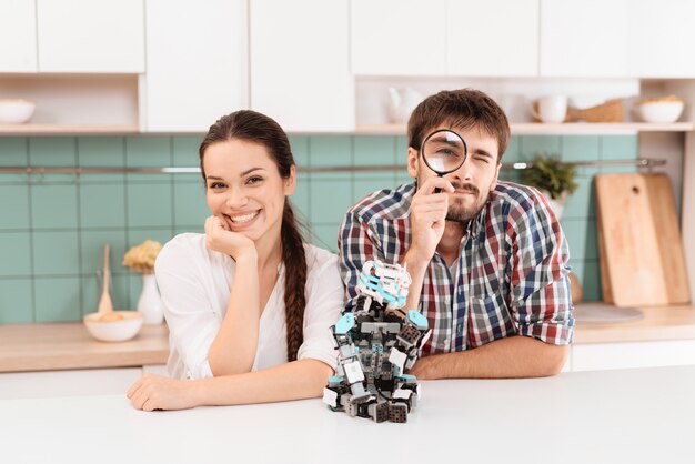 A guy and a girl are posing in the kitchen.