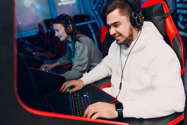 Guy and girl gamers playing gaming game on computer at club Concept esports