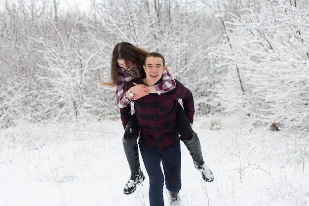 Il ragazzo e la ragazza si riposano nei boschi invernali marito e moglie nella neve coppia giovane