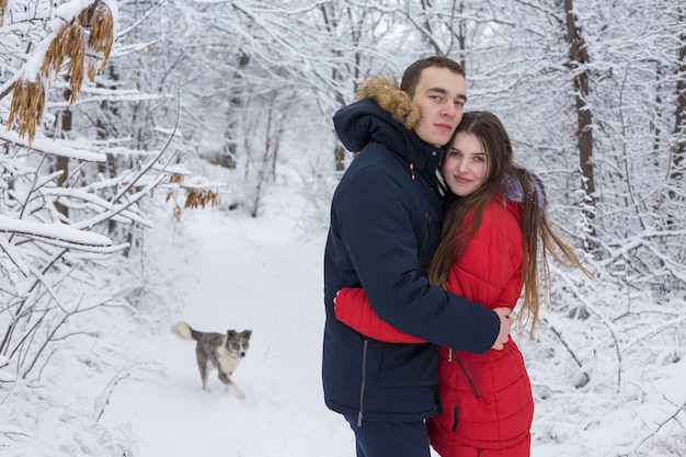 男と女は冬の森で休む夫と妻は雪の中で若いカップル