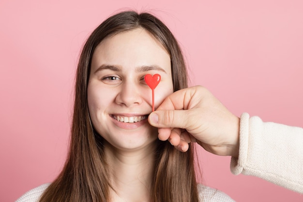 Guy and girl holding heart together on pink background valentine's day concept