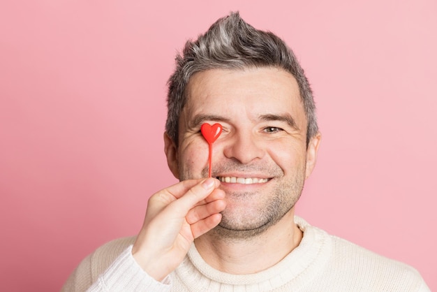 Guy and girl holding heart together on pink background valentine's day concept