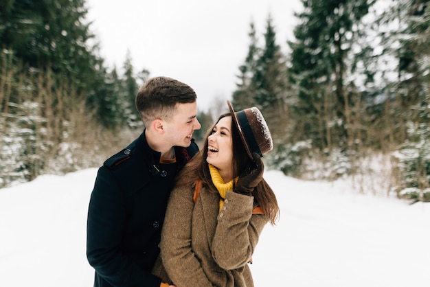 Guy and girl laugh in the winter forest, close-up