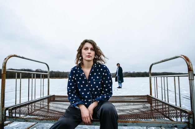 A guy and a girl in pajamas on the ice of a frozen lake