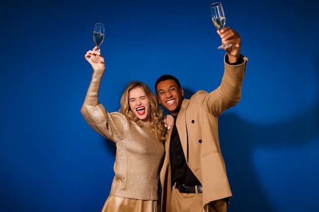 Guy and girl raising glasses looking at camera