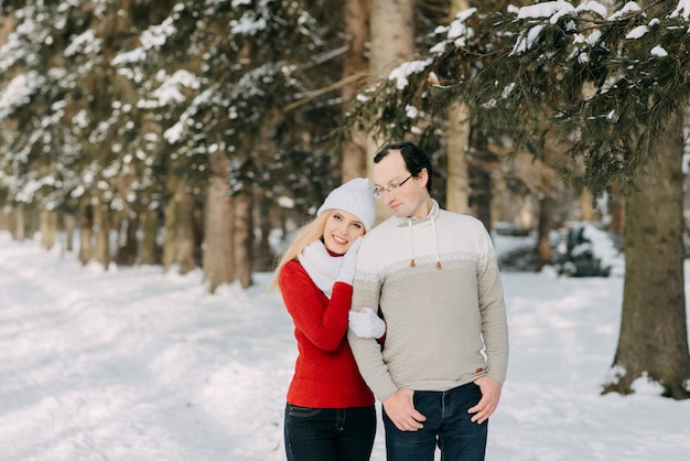 Guy and girl walk ,have fun in the forest in winter