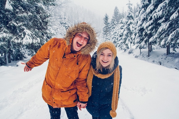 Guy and girl walk and have fun in the forest in winter.