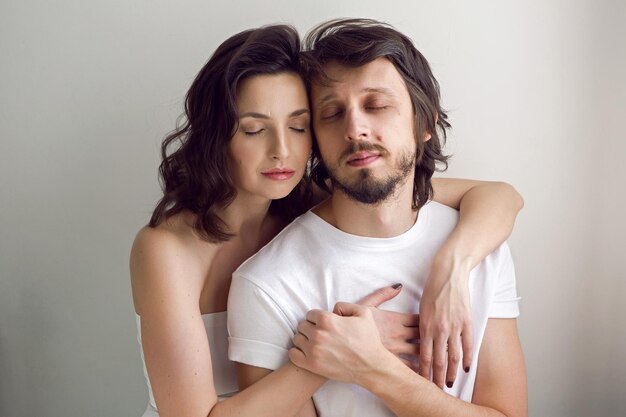 Foto un tizio e una ragazza su uno sfondo bianco nello studio sono felici della vita