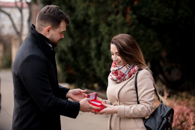 Парень дарит девушке коробку с подарком