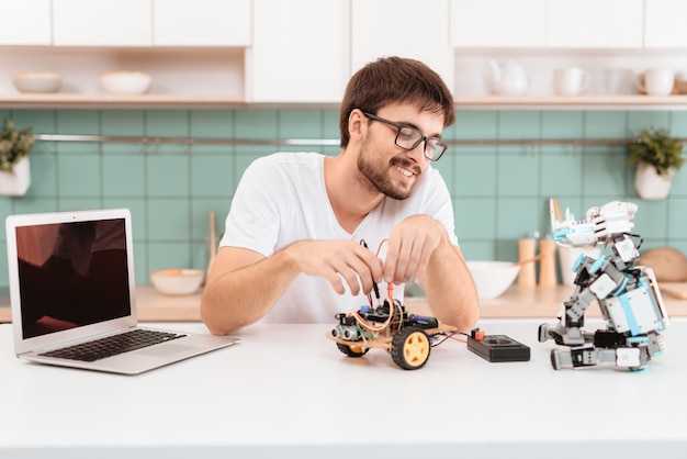 The guy in the glasses is busy constructing the robot.