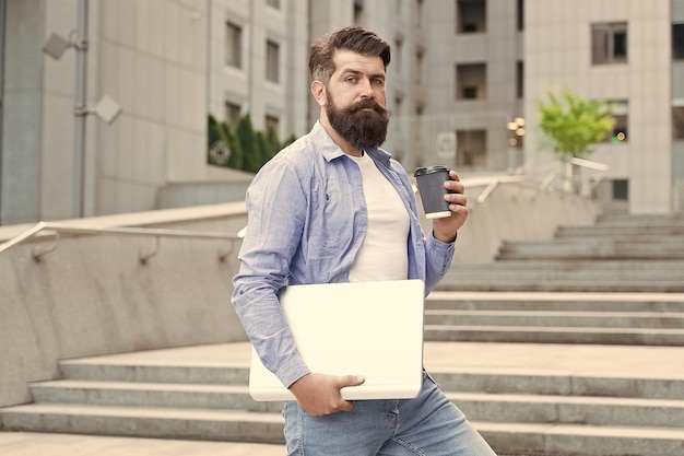 Guy going to work urban background man with laptop walking\
empty street business center reopening modern life hipster modern\
worker with notebook modern technology work in social distancing\
era