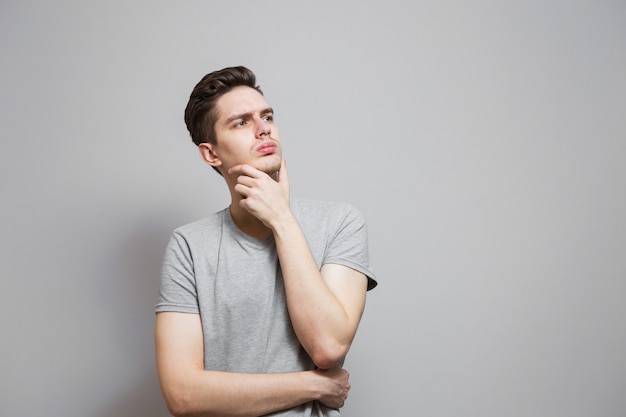 a guy in a gray t-shirt with emotions on his face.