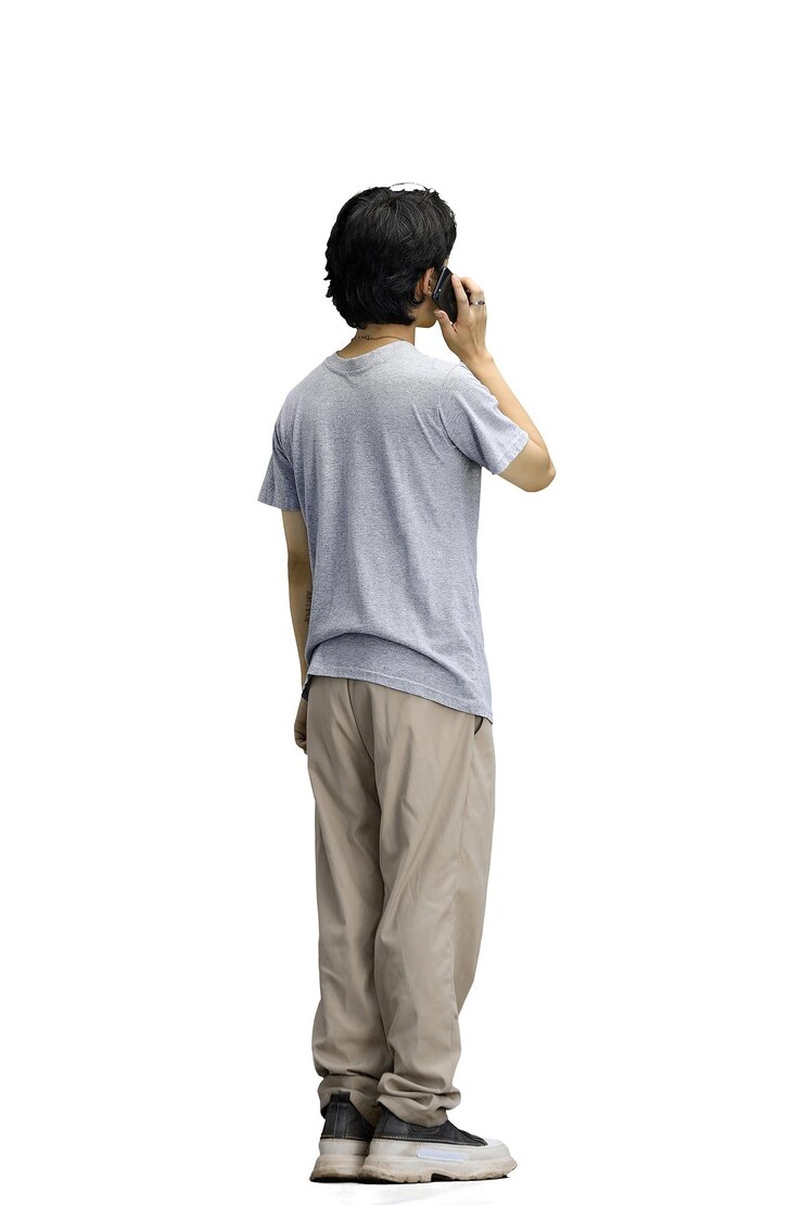 Photo 白い背景に灰色のtシャツを着た男がフルレングスで電話で話している