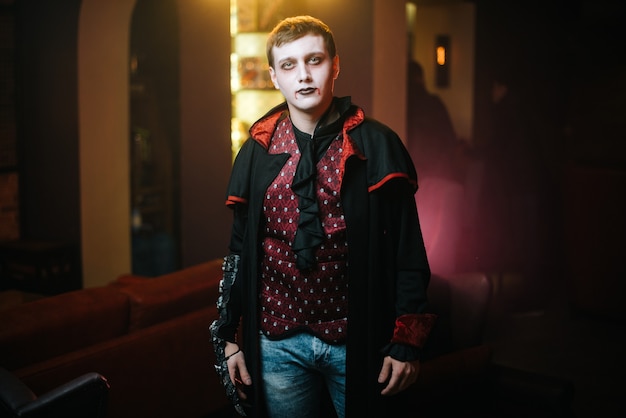 Foto il ragazzo con il costume di halloween del conte dracula sta guardando la telecamera