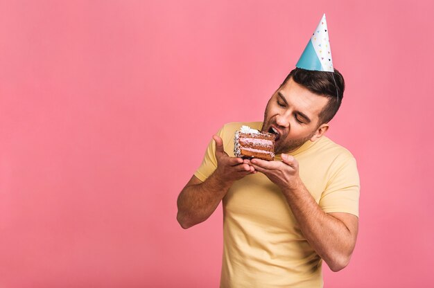 Guy tenere una piccola torta e festeggiare il compleanno. solitario alla festa. celebrando da solo.