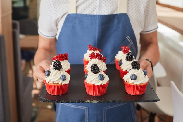 Guy holding a dessert with raspberries closeup