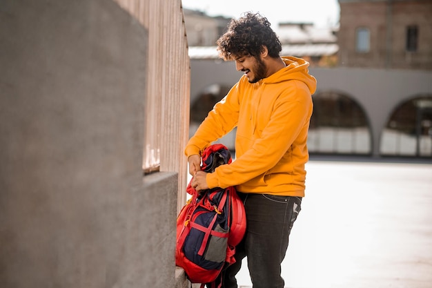 Guy in a hoodie. Dark-haired young guy in orange hoodie with a backpack