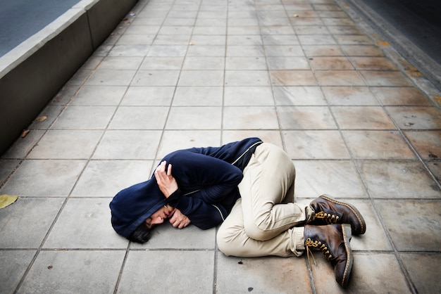 Guy in a hoodie fetal position on the floor