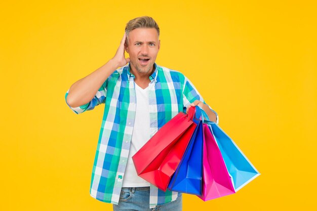 Guy houdt cadeau vakantie flash verkoop en speciale aanbieding cyber maandag in winkel klant succesvolle geschokte man winkelen knappe vrolijke man met papieren zakken aankoop in papieren zakken Perfecte dag