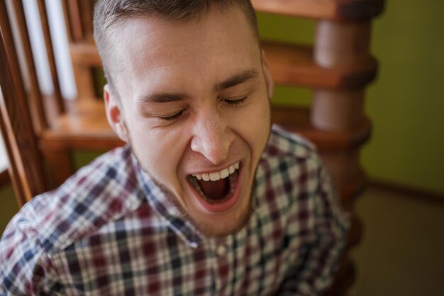 写真 格子縞のシャツの男はあくびをします