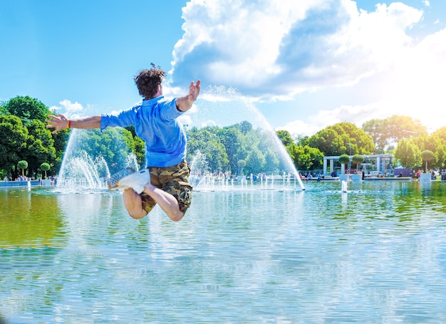 男は空中に浮かんでいます。男は噴水の背景に対して空中に浮かんでいます