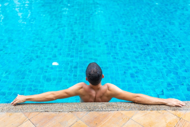 Il ragazzo si sta rilassando a bordo piscina in una calda giornata estiva