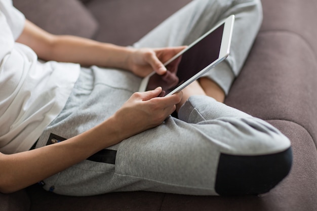 the guy is sitting on the couch with a tablet in his hands