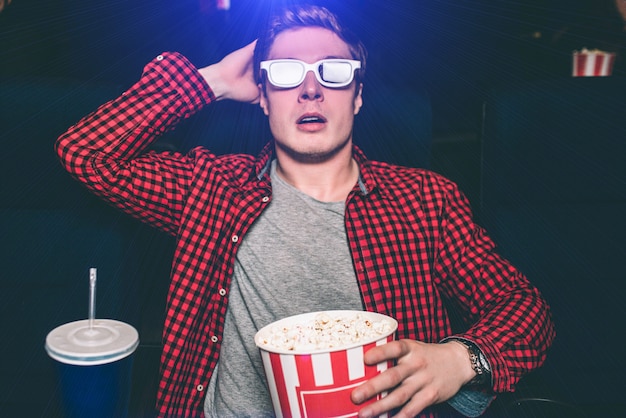 Guy is watching movie in cinema hall